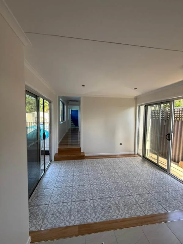 Living area from the same renovation, patterned tiles opening onto the deck, a Seaforth Builders project on the Gold Coast